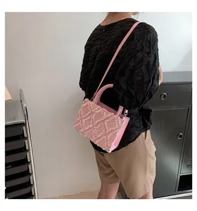 Detailed view of a pink quilted tote bag with fringe edge texture and leather strap