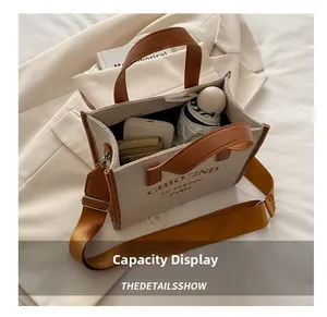 Vue intérieure montrant la grande capacité du cabas en toile beige avec des objets du quotidien