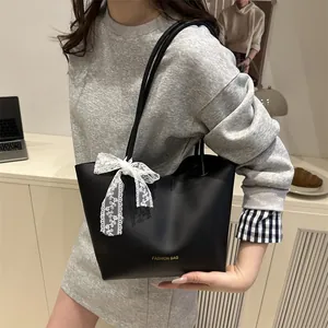 Large black tote bag with lace bow and gold text, trendy fashion shoulder bag for women