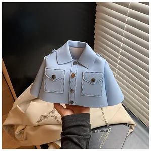 Close-up of creative light blue shirt-shaped crossbody bag with silver chain strap