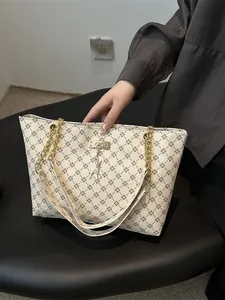 Minimalist beige tote bag with geometric floral patterns and elegant deer pendant charm