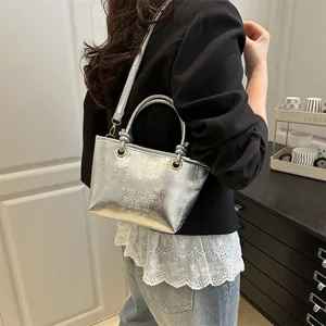 Silver metallic bucket bag with embossed lettering and stylish wrinkled texture