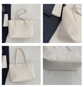 Detail showing white pleated texture and gold metal studs on a minimalist tote bag