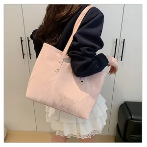 Detail of pink tote bag showing unique marble texture and golden rivet strap attachment