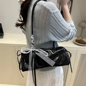 Fashionable black faux leather shoulder bag with white lace bow and silk scarf detail