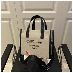 Dettaglio della borsa tote in tela con finiture in pelle nera e logo stampato LE SEREIN