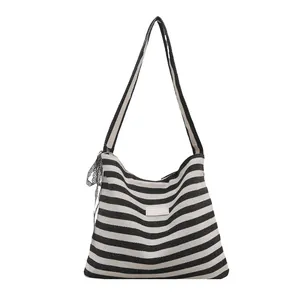 Chic black and white striped canvas tote bag with adjustable strap and side lace detail