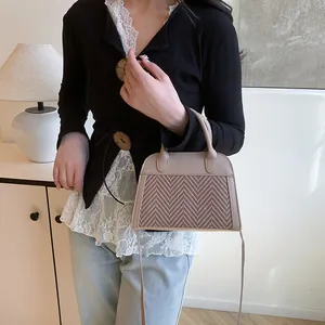 Detail of retro trapezoid handbag with khaki leather and brown woven texture stitching