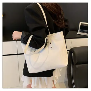 Detail of white nylon tote bag with subtle glossy texture and reinforced silver rivets