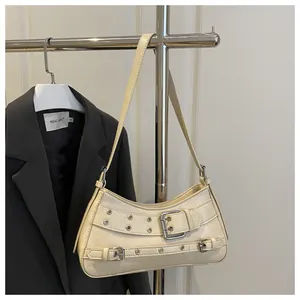 Detail der cremeweißen Unterachseltasche mit silbernen Metallösen und Gürtelschnallen