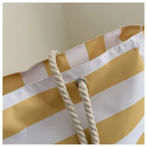 Details der gelb-weiß gestreiften Canvas-Tasche mit robusten Baumwollseilgriffen