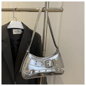 Detail der silbernen Spiegel-Baguette-Tasche mit Metallösen und Gürtelschnallen