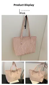 Detailed view of pink tote bag with unique crinkled texture and gold stud accents