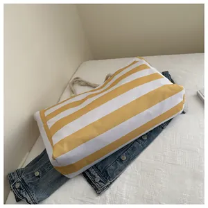 Nahaufnahme der gelb gestreiften Segeltuchtasche mit Baumwollseilen auf Jeansstoff