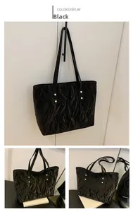 Detailed view of black tote bag with unique cloud texture and gold rivet hardware