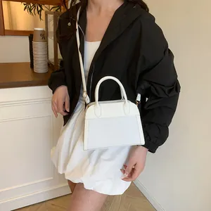 Detail showing the white patchwork texture and golden hardware of this stylish tote bag
