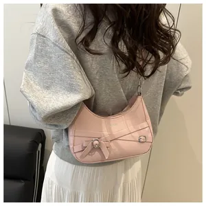 Sac demi-lune rose avec détails de laçage, nœud et bandoulière en chaîne métallique