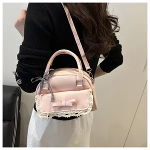 Pink faux leather bag with white lace trim and double bows shown on model shoulder
