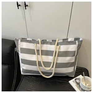 Nahaufnahme der Canvas-Tasche mit grauen Streifen, Seilgriffen und Seitentasche