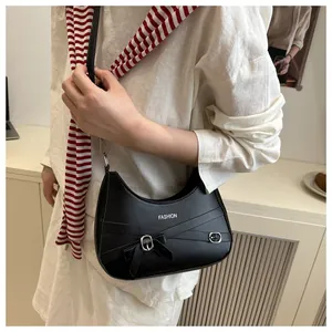 Détail du sac demi-lune noir avec décoration de nœud et boucle en métal argenté