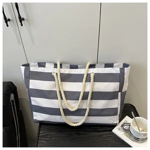 Detailaufnahme der blau-weiß gestreiften Canvas-Tasche mit Seilgriffen und Seitentasche