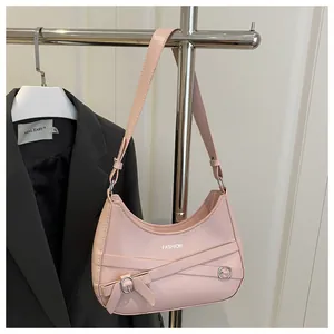 Détail du sac sous le bras en cuir rose clair avec nœud et boucle métallique chic