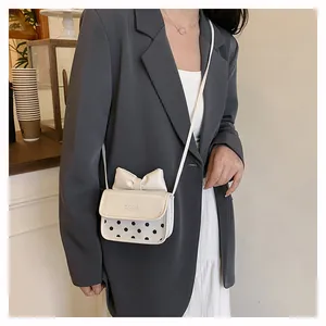 Detailed view of kids vintage crossbody bag with polka dots and a decorative bow