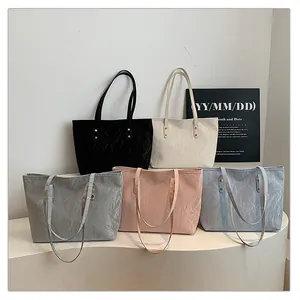 Detailed group view of textured oversized tote bags in five assorted modern colors