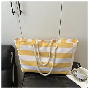 Nahaufnahme einer gestreiften Canvas-Tasche mit dicken Baumwollseilgriffen im Café-Stil