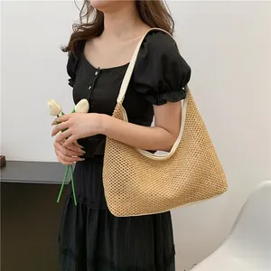 Minimalist woven straw hobo tote bag with leather straps for beach and vacation style