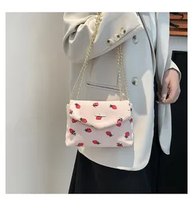 Détails du sac bandoulière en velours côtelé rose avec motifs fraises et chaîne dorée
