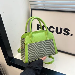 Detailed view of lime green pillow bag with grey herringbone fabric panel and dual handles