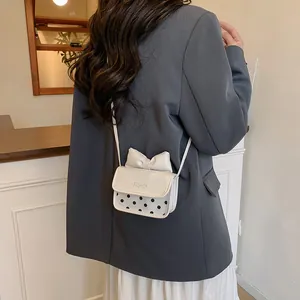 Mini cream crossbody bag with a decorative bow and black polka dots for girls