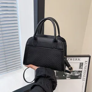 Detail of vintage black patchwork boston bag with dual handles and fashion embossing