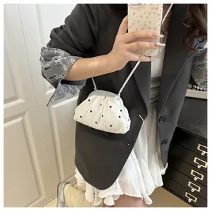 Selfie miroir montrant un petit sac seau crème avec broderies de fleurs noires