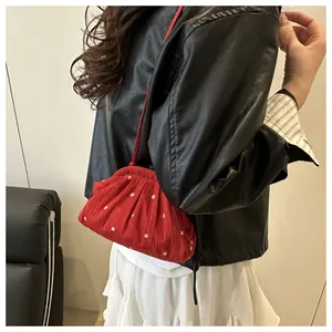 Détails du sac seau rouge avec motifs de fleurs blanches et texture plissée douce