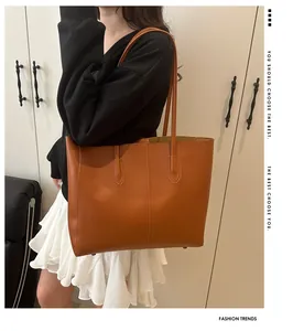 Brown leather tote bag featuring vertical stitching and dual handles on shoulder