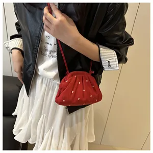 Modèle portant un sac seau bandoulière rouge avec broderies de fleurs blanches