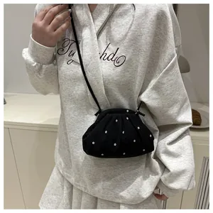 Détail du sac nuage noir à imprimé floral blanc avec bandoulière fine et design plissé