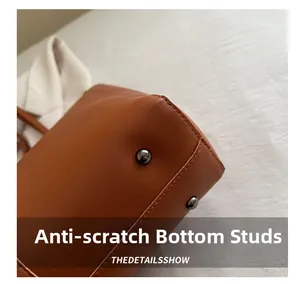 Close-up of protective gunmetal bottom studs on the brown leather tote bag base