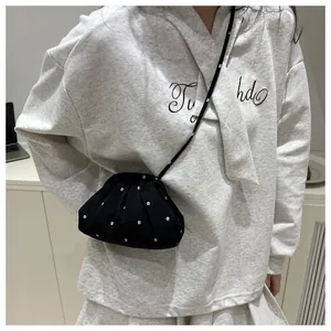 Détail d'un sac nuage noir avec broderie florale blanche et bandoulière réglable