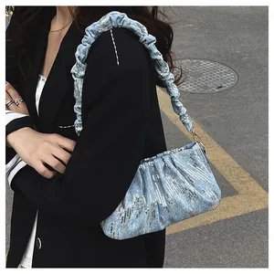 Detalle de bolso de lentejuelas azul claro con tejido plisado y bordado plateado fino