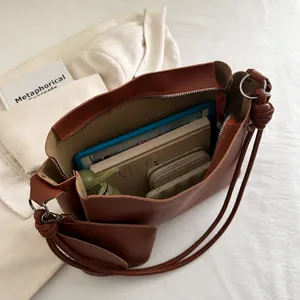 Detailed interior view showing large capacity storage for tablets and essentials in brown bucket bag