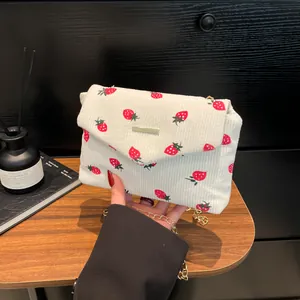 Sac à bandoulière en velours côtelé blanc avec motifs fraises et bandoulière chaîne dorée