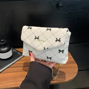 Sac à bandoulière en velours côtelé avec imprimé nœud noir et chaîne dorée élégante