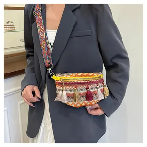 Detail of woven bohemian fanny pack with colorful tassels and geometric strap on model