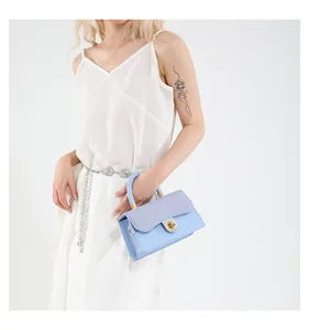 Détails du sac à main bleu clair avec rabat contrasté et fermoir rotatif doré poli