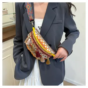 Close-up of bohemian crossbody bag featuring ethnic embroidery and colorful tassel fringe