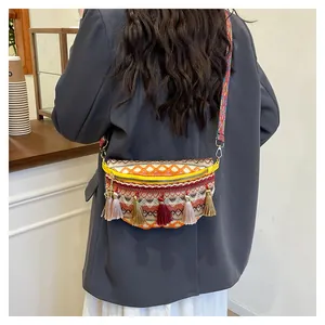 Close-up of bohemian woven crossbody bag featuring colorful ethnic patterns and long tassels