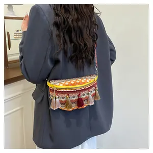 Detail of woven bohemian waist bag with colorful fringe and ethnic geometric patterns